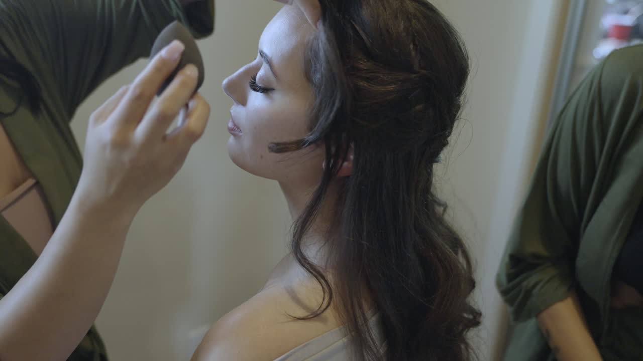 una toma estática de varias damas de honor trabajando en diferentes partes de una novia