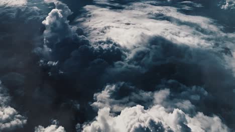 point of view from top, bright dark cumulus clouds in the blue sky