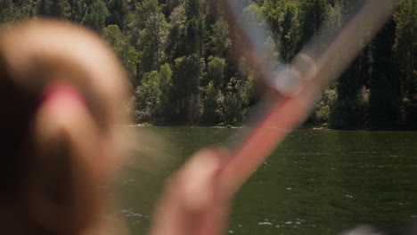 wild forest on sloped coast and yacht with tourist on summer day. travelling by vessel past wood hills on lake bank. river journey at nature resort