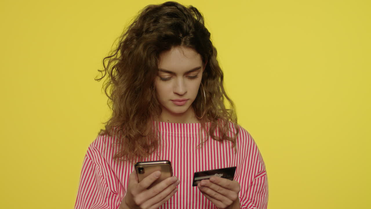 mujer joven escribiendo el número de tarjeta de crédito en el teléfono móvil para comprar en línea