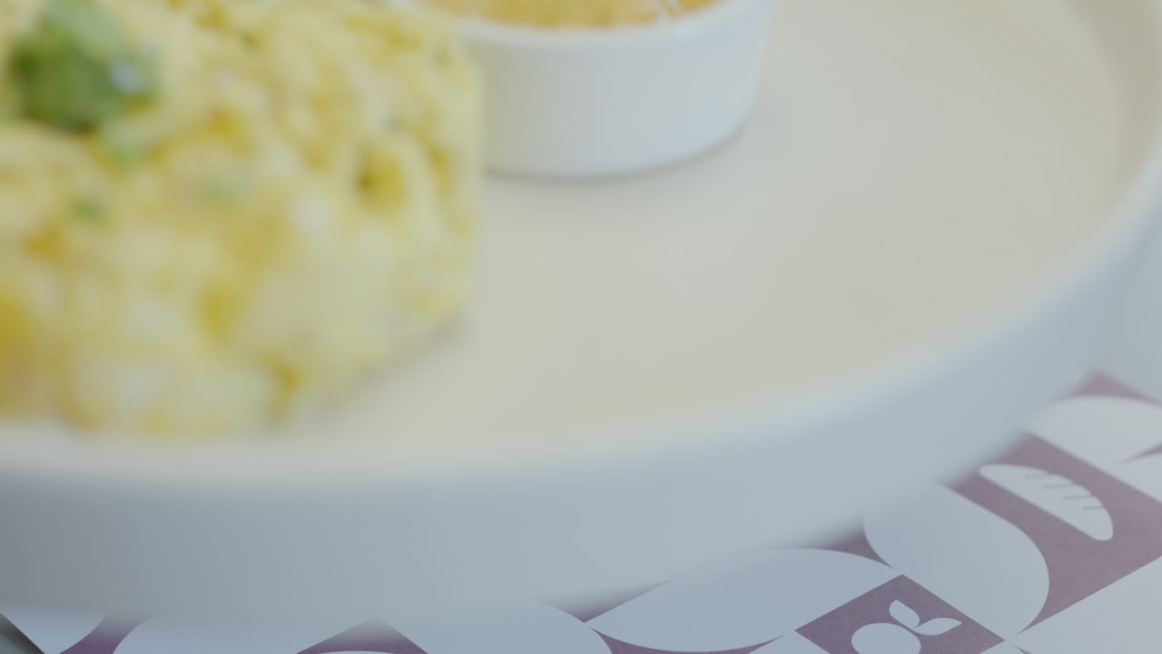 Close-up of a traditional dish that combines juicy roast meat, mote pillo prepared with mote, egg and finely chopped scallions, accompanied by artisanal chili sauce