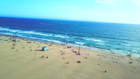 sunny day in venice beach california drone ocean view over sand panning left.