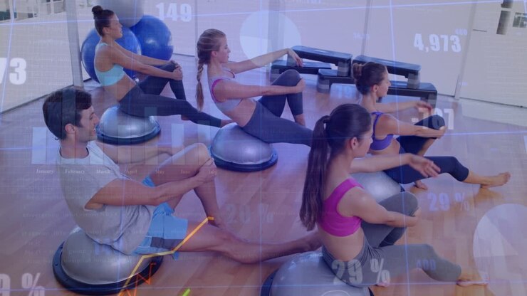 On cue group leaning back, rotating torsos on BOSU trainers for core fitness, charts overlaying