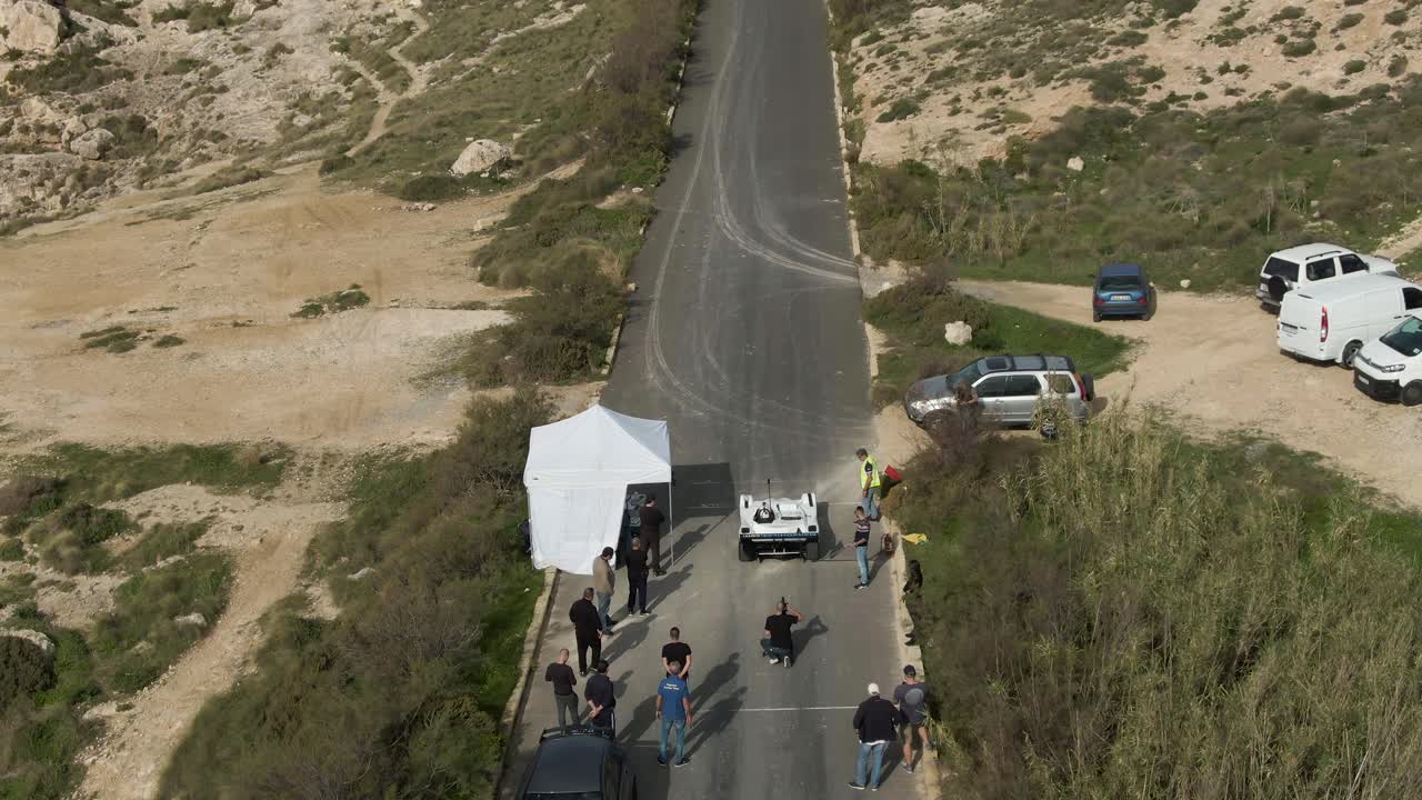coche de carreras blanco preparándose para conducir en la pista de carreras en un clima brillante - toma aérea