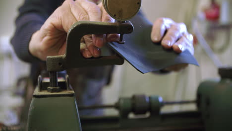 bespoke shoemaker measuring and preparing leather for shoe