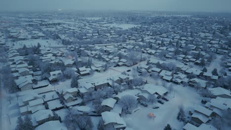 drone shot of a residential sub-urban area covered in frost and snow during a misty winter evening