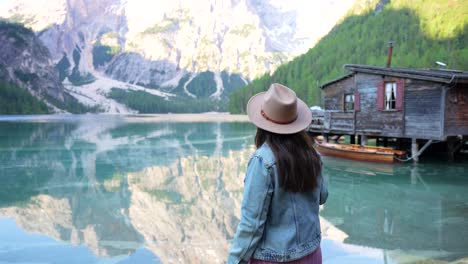 Mujer-Solitaria-Con-Sombrero-En-Lago-Di-Braies-Disfrutando-Del-Paisaje-Natural