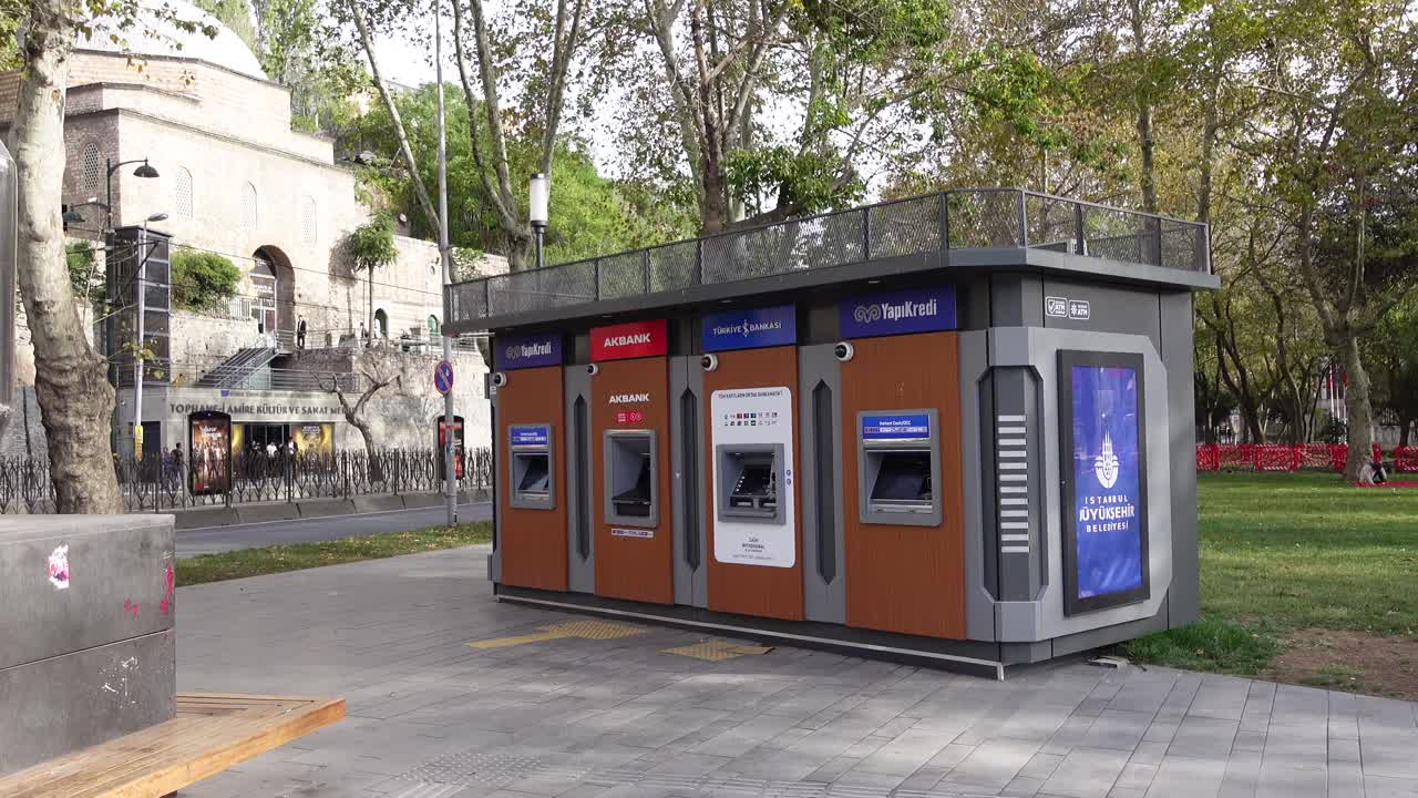 Diversi sportelli bancomat in un parco cittadino