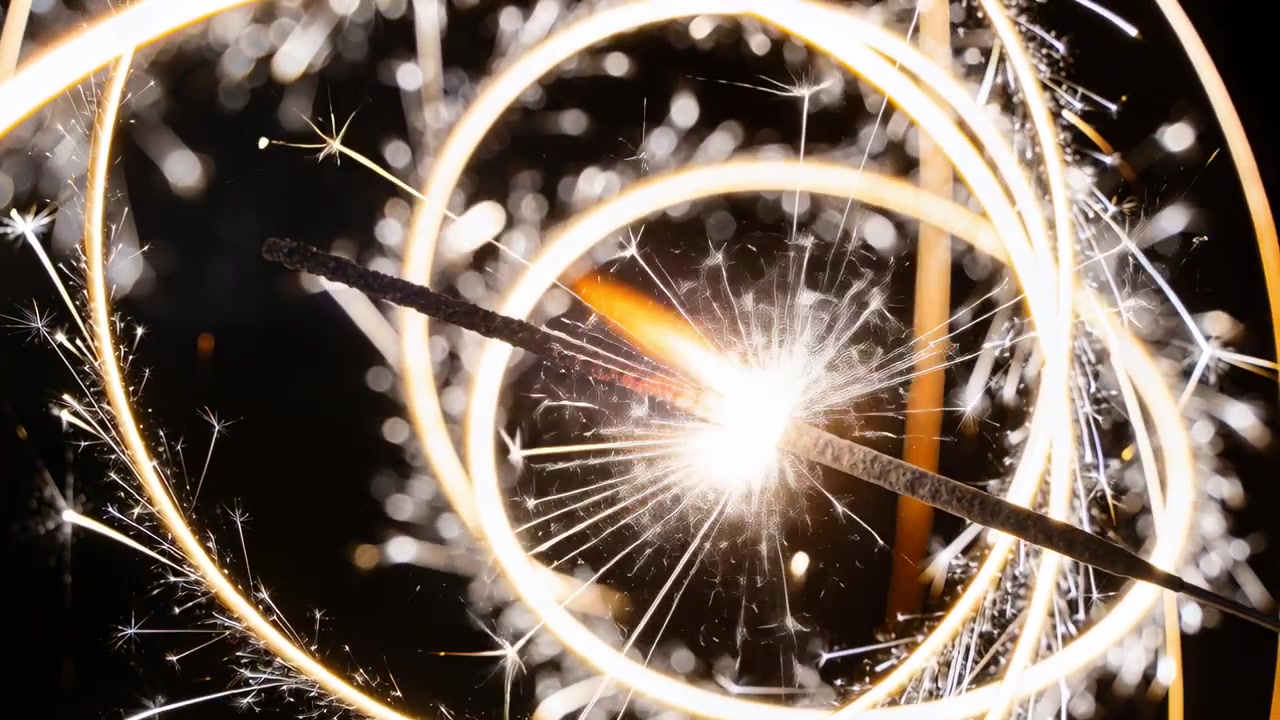 Accendendo un bengala, questo emette scie di luce a spirale e scintille in uno studio buio.