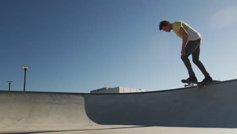 Kaukasischer-Mann,-Der-An-Einem-Sonnigen-Tag-Auf-Dem-Skateboard-Reitet-Und-Springt