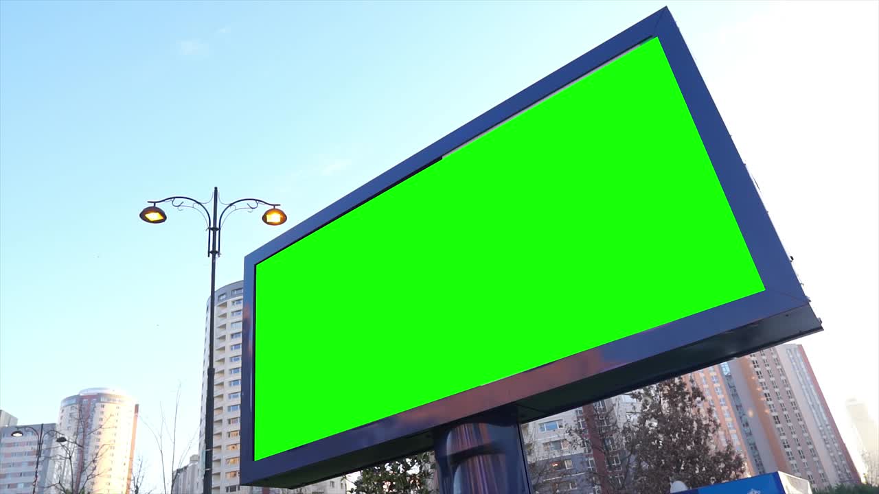 Grøn skærm reklameskilt i bymiljø. Tomt reklamepanel, banner til markedsføring. Tomt chroma key skilt.