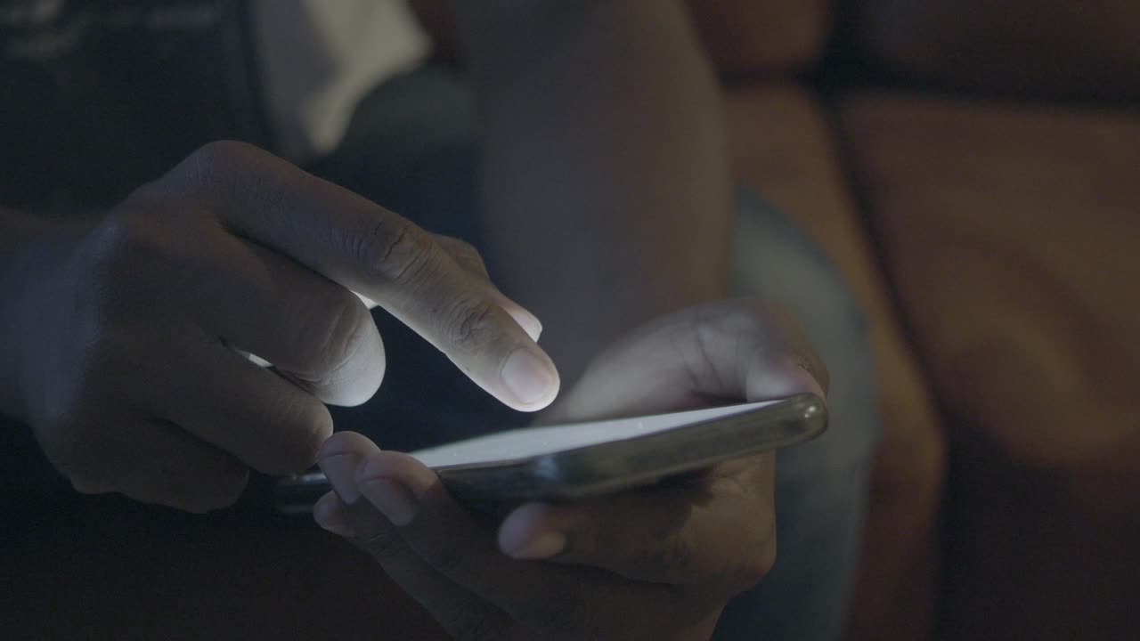 persona que utiliza un teléfono inteligente por la noche