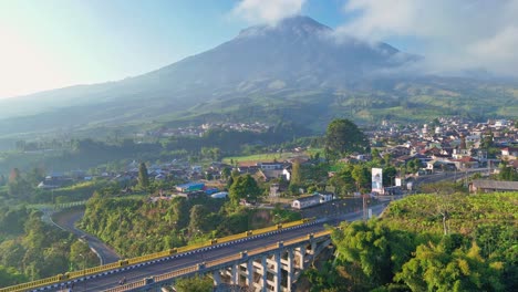 massive mount sumbing and old road bridge, aerial view