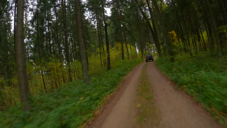 Cámara-Drone-Fpv-Rastrea-Un-Vehículo-Todoterreno-Que-Se-Mueve-Rápidamente-En-Un-Camino-Forestal