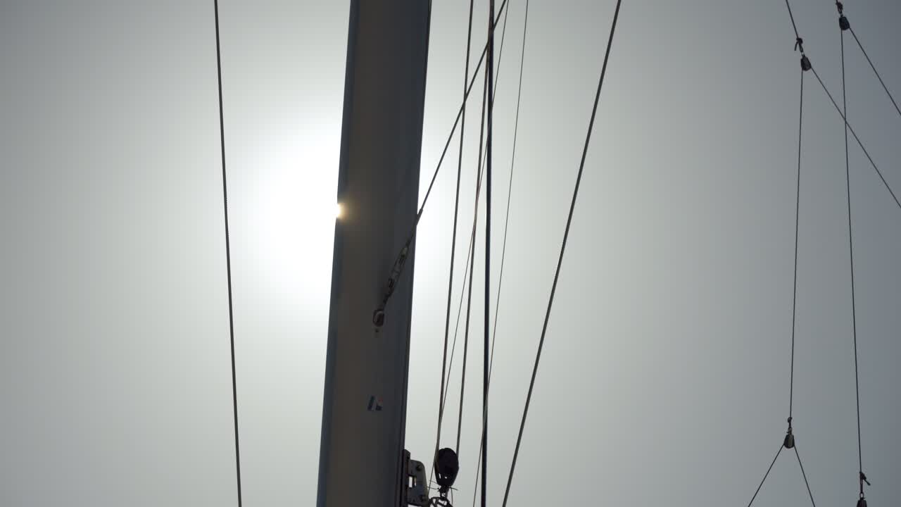 Tramonto dietro alcuni rilievi da un catamarano a vela.