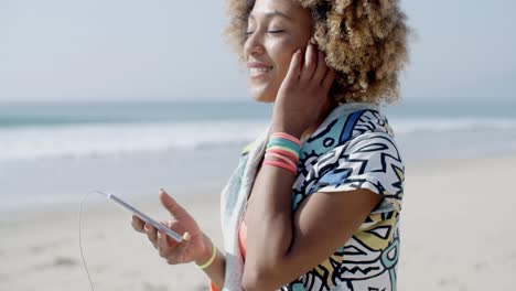 chica escuchando la música de un teléfono inteligente