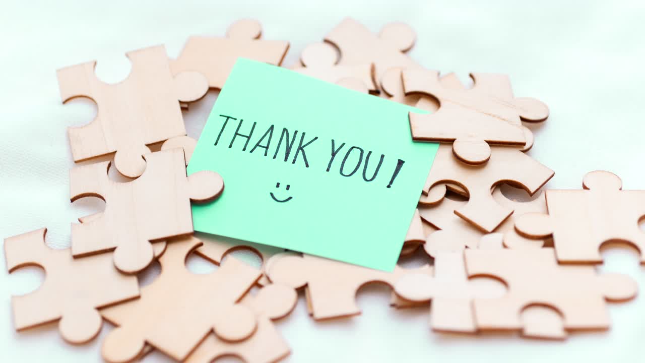A visual representation of appreciation featuring a thank you note amidst scattered puzzle pieces.