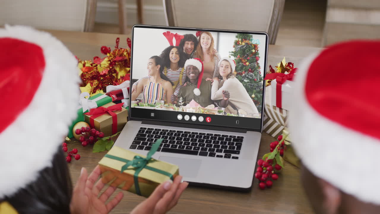 pareja diversa teniendo videoconferencia de navidad con personas diversas