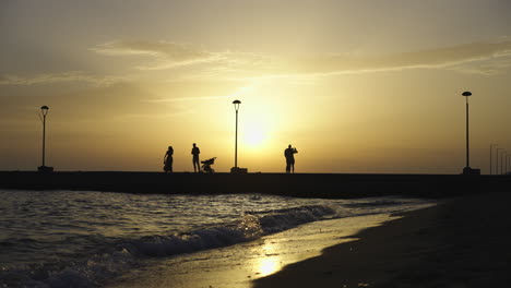 silhouettes on the pier at sunset