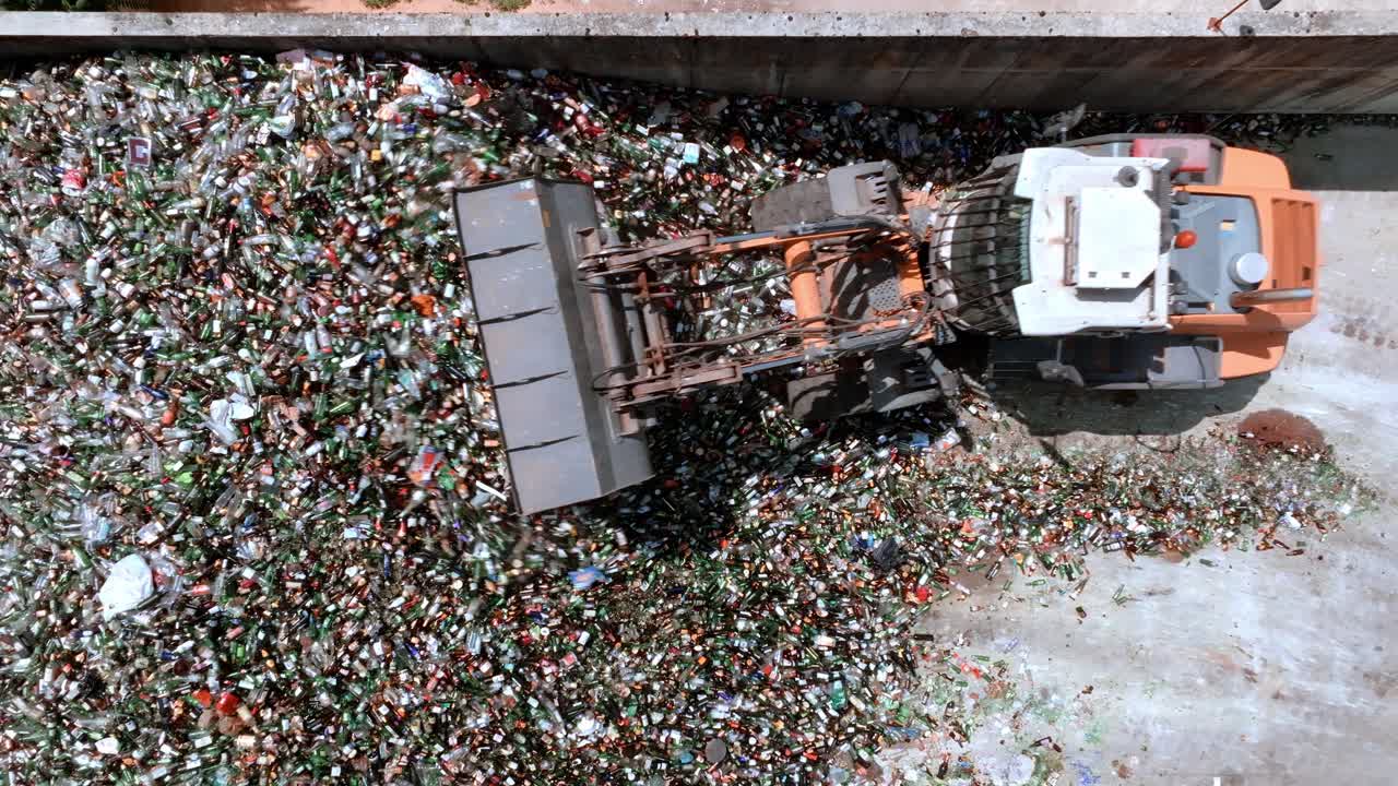 vista aérea de drones desde el centro de reciclaje de vidrio del almacén, siguiendo el concepto de reciclaje de vidrio de la excavadora de carretilla elevadora