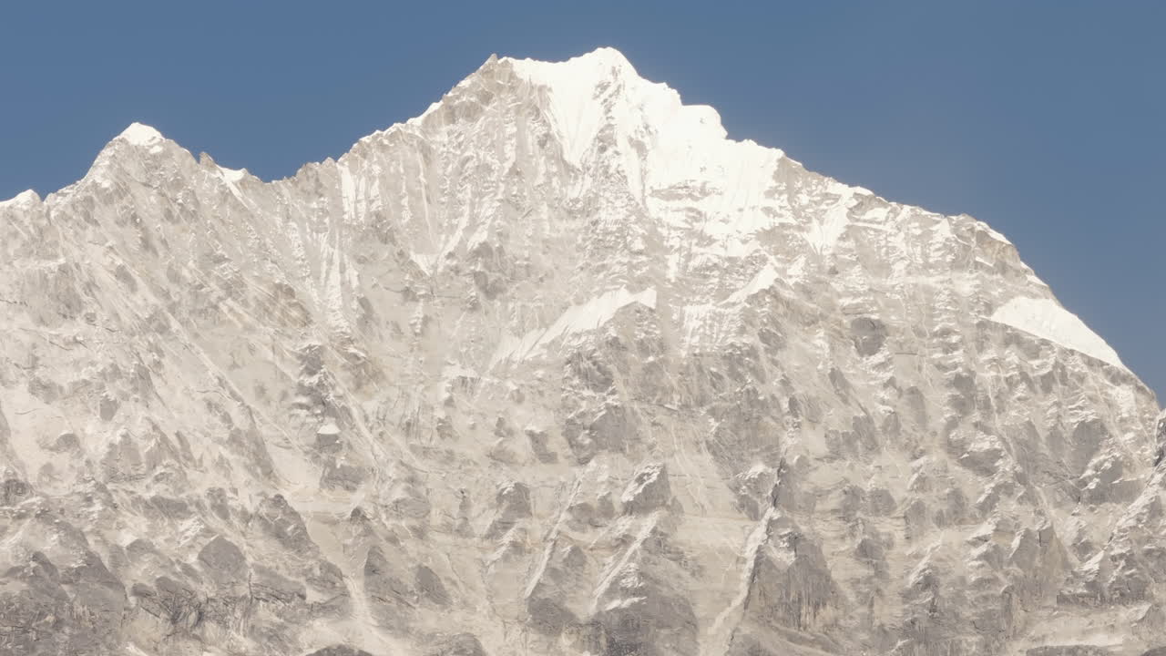 Aerial tracking shot behind trees, revealing the snowy peaks of the Everest trail