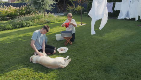 family doing laundry and playing with dog in the backyard