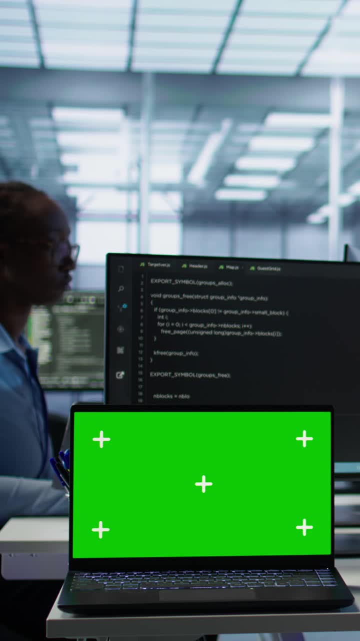 Green Screen Laptop on Desk in Modern Office with Coder