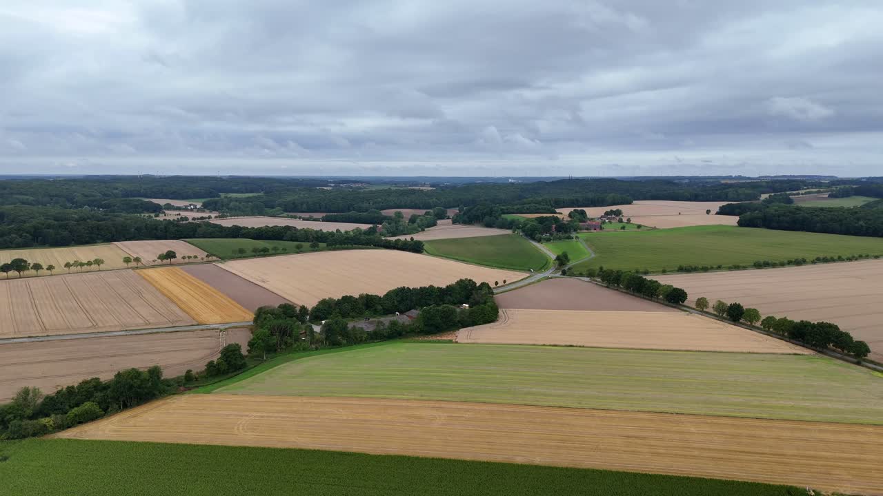 Mystic clouds at sky of American countryside. Farm fields and rolling hills in distance. Quiet and peaceful landscape of United States. Cultivated wheat and soybean fields. Panorama aerial wide shot