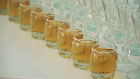 glasses with alcohol in a row on a white table