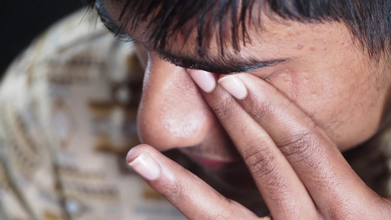 Close-up of a person with hand on eye