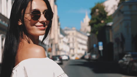 woman in sunglasses walking down a city street