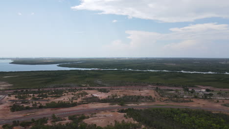 disparo de dron de rotación lenta de los matorrales del brazo este moviéndose hacia el horizonte y la ciudad de darwin, territorio del norte