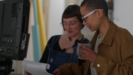 female film director and assistant checking script shooting movie or video in studio