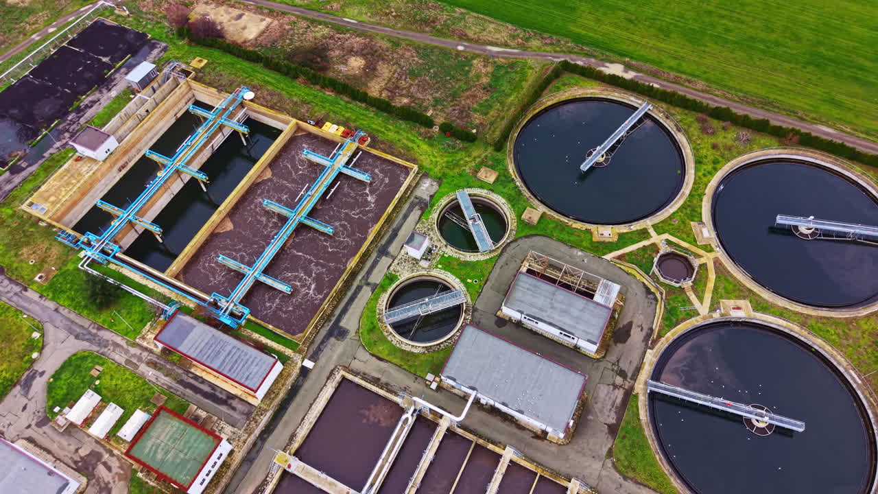 Aerial view of a water treatment facility showing tanks and equipment used for wastewater management in a rural area during daylight hours