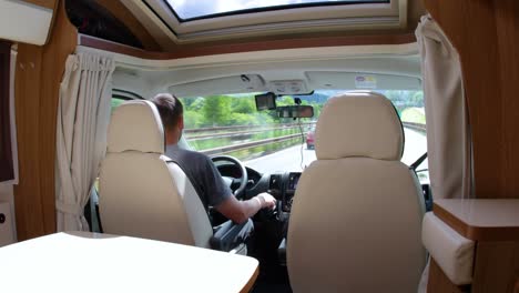 man driving on a road in the camper van