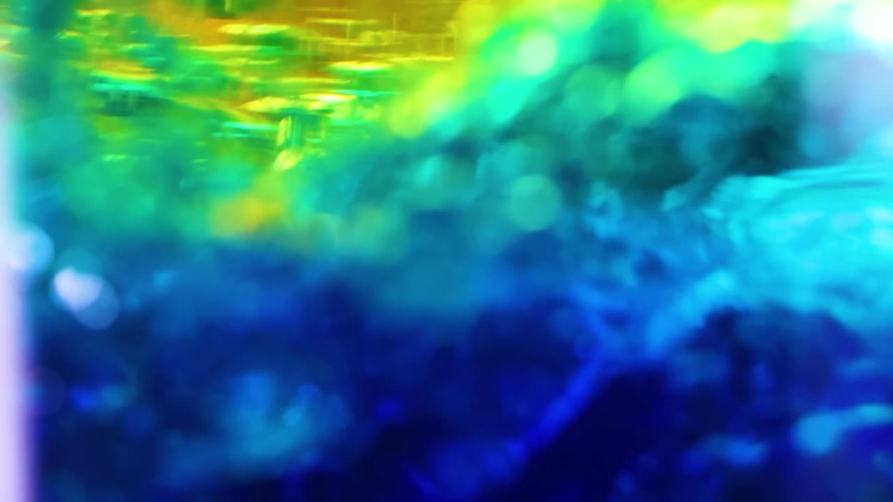 Close-up view of blue and yellow liquids interacting with dynamic motion and vibrant colors.