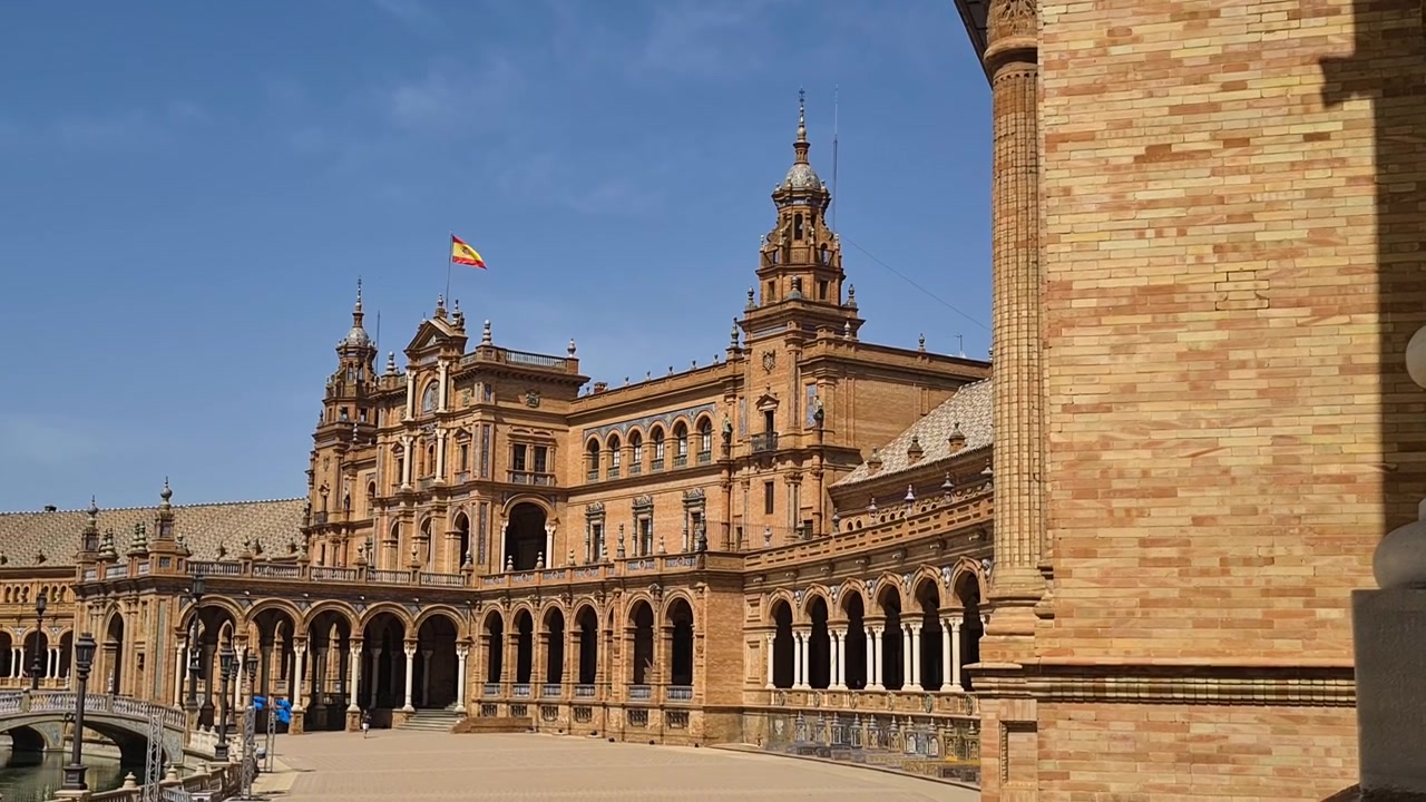 Bandeira espanhola tremulando no topo de um edifício na Plaza de España, Sevilha, em um dia quente de verão