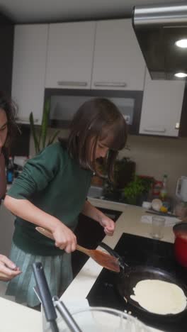 child cooking pancakes in a kitchen