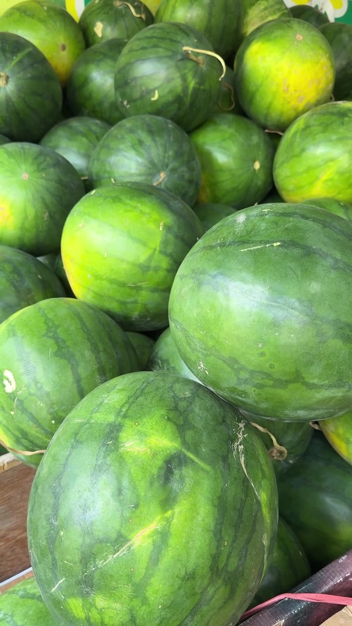 Pila di angurie intere fresche in una cassetta da mercato