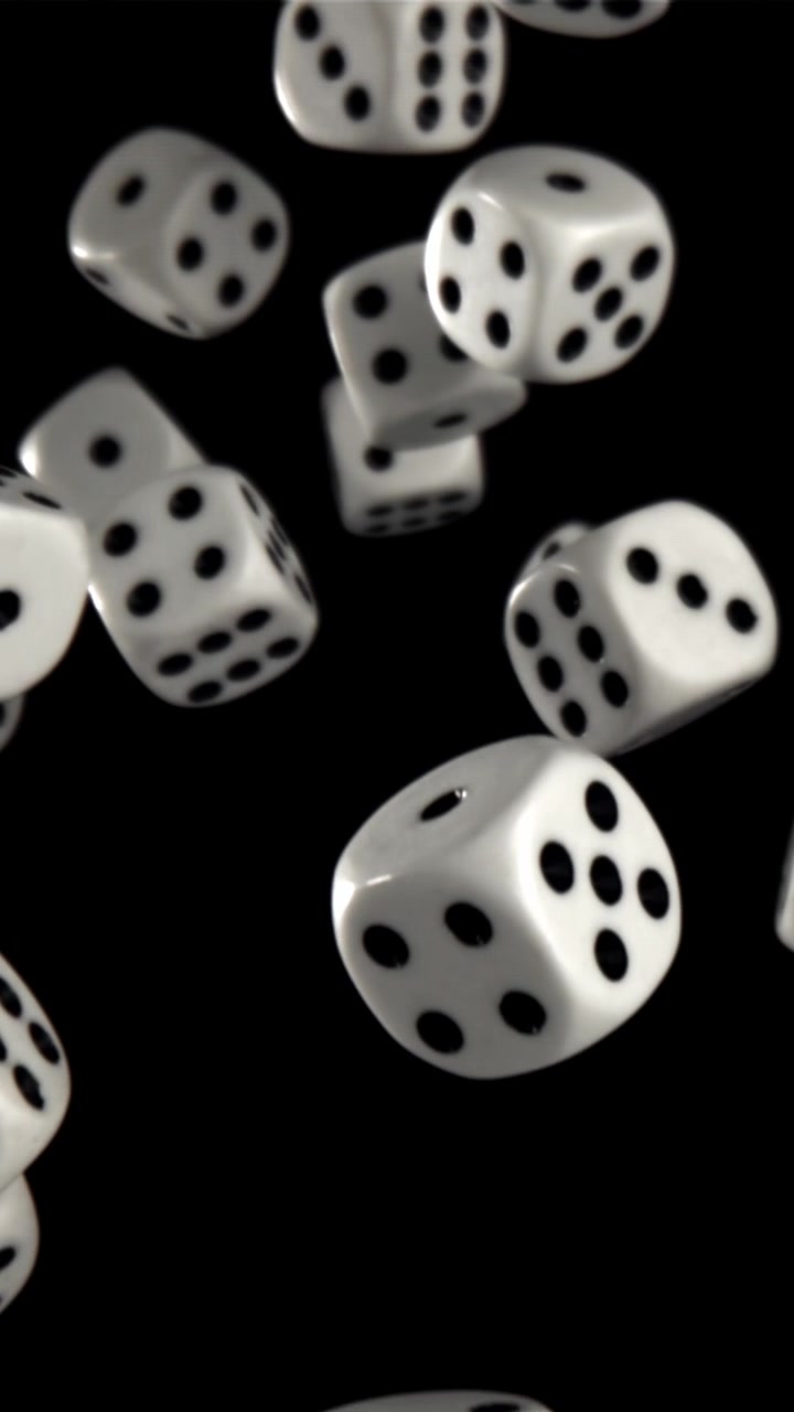 Hvide terninger, der svæver opad i slowmotion på sort baggrund