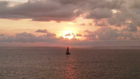 static shot sailing boat passing on the sea during epic cloudy sunset