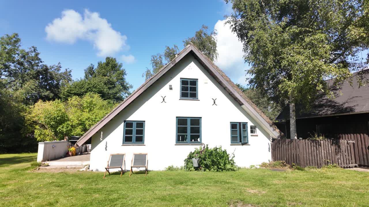 Lovely, traditional white cottage home in the Danish countryside in summer