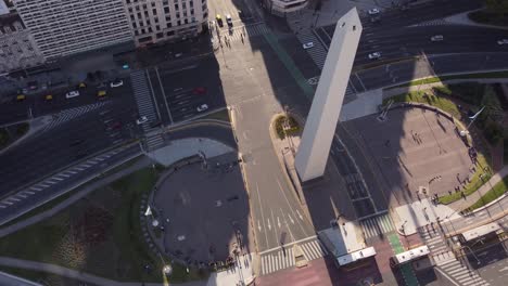 Aerialo-Umlaufbahnaufnahme-Des-Berühmten-Obelisken-Obelisk-Denkmals-In-Buenos-Aires-Mit-Verkehr-Während-Des-Sonnenuntergangs