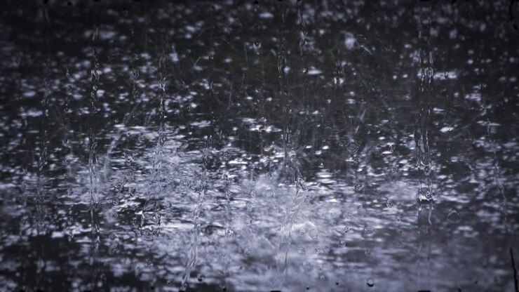 Heavy rain shower downpour cloudburst rainfall behind the glass.