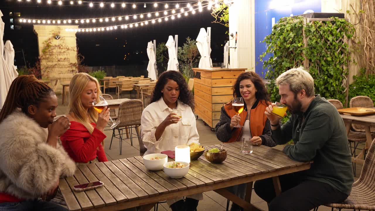 Un grupo de amigos disfrutando de unas bebidas en un restaurante al aire libre