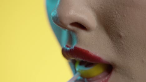 woman-licking-cherry-popsicle-with-seduction,-mouth-close-up-shot-on-yellow-background