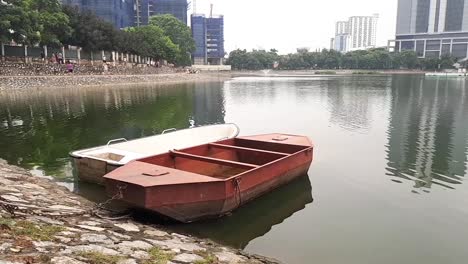 Vista-De-Los-Barcos-De-Pesca-Hechos-De-Metal-A-Orillas-De-Un-Pequeño-Lago-En-Medio-De-La-Ciudad