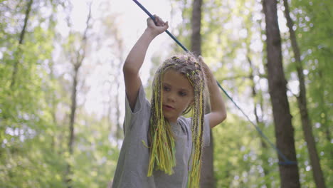 in the summer camp my daughter learns to overcome rope obstacles and rock climbing. teaching children about tourism and hiking