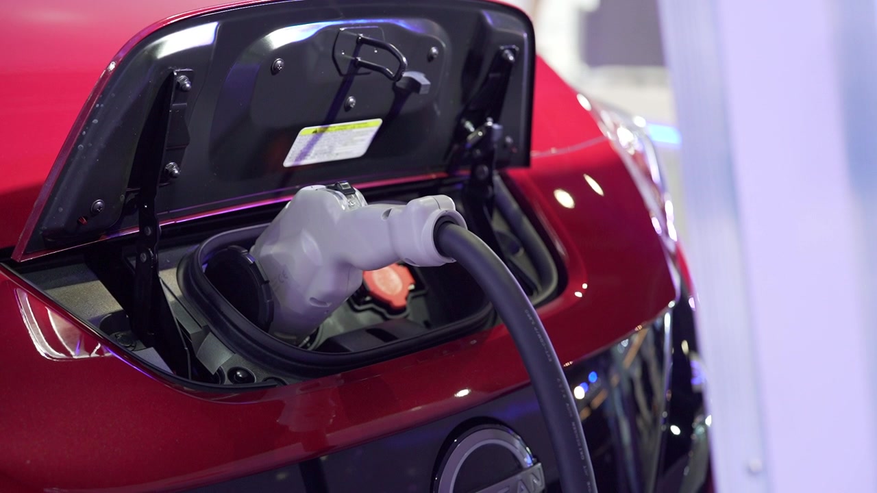 Close Up Shot Of A Red Electric Vehicle Plugged On It's Fast Car Charger