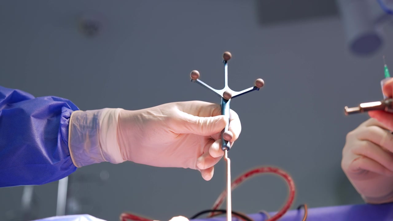 Doctor's hand in latex glove holds a surgical probe. Another medic is holding a syringe. Low angle view.